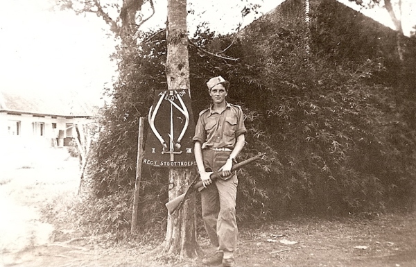 Onbekende militair met Lee Enfield geweer naast het schild van het 3e peloton, 2e compagnie, 7 RS, vermoedelijk in 1947 en op Sumatra.